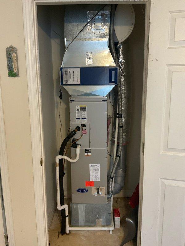 Diagnosed 2011 Carrier heat pump system with significant refrigerant loss. Documented current installation configuration in utility closet, noting proper ductwork connections and condensate drainage. Recommended full system replacement due to age of unit and R410A refrigerant requirements.