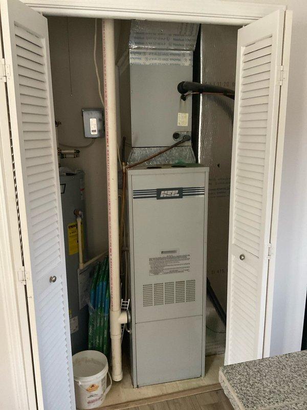 Inspected 38-year-old non-operational HVAC system in customer's newly purchased condo. System is original to the property and requires full replacement due to age and failure. Documented current installation including furnace unit with HSC branding and associated ductwork, ventilation, and exterior components.