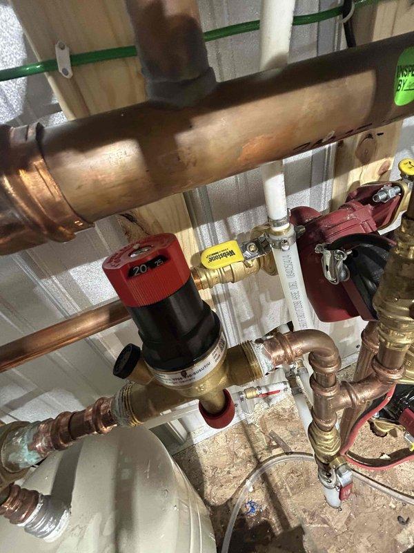 Completed warranty service on boiler system. Inspected pressure regulator valve assembly and gauge functionality within the copper pipe network. Verified proper operation of the heating distribution system components after service.