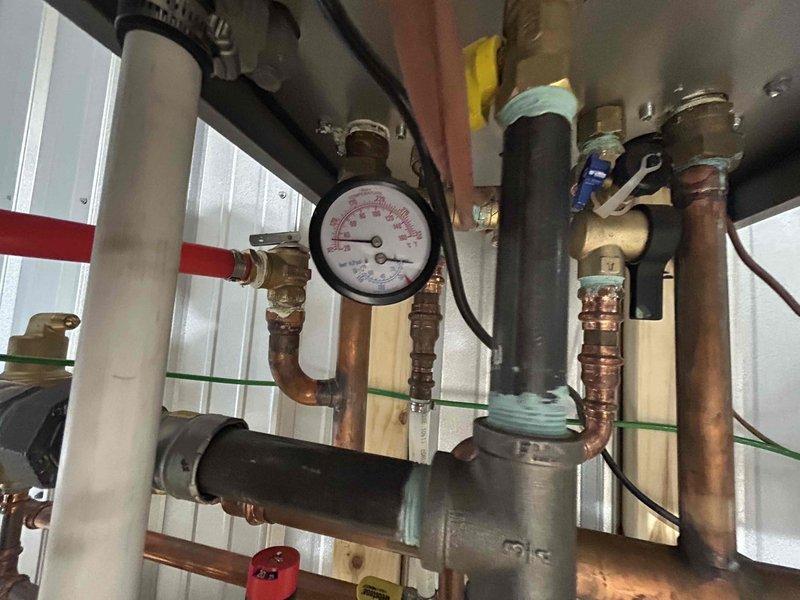 Completed warranty service on boiler system. Inspected pressure regulator valve assembly and gauge functionality within the copper pipe network. Verified proper operation of the heating distribution system components after service.