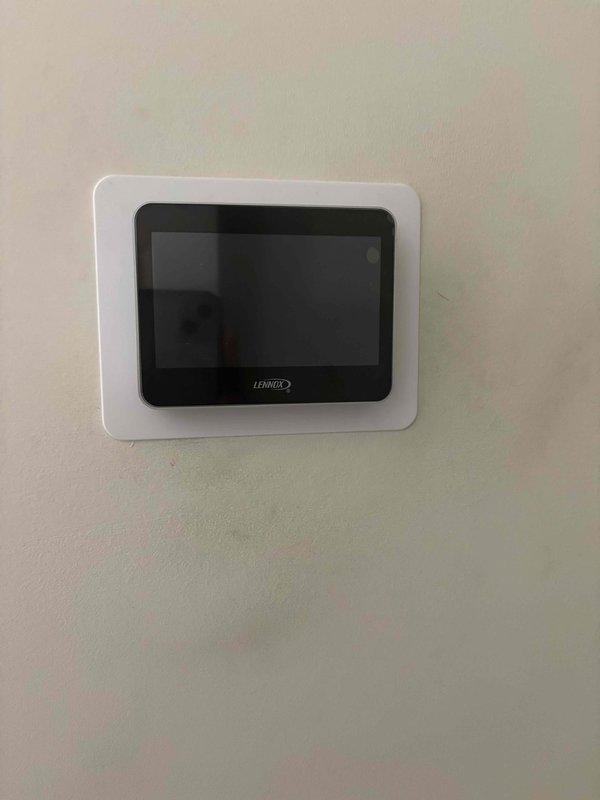 Successfully installed a complete Lennox heat pump system, including the digital thermostat with touchscreen display mounted on the interior wall. The installation included proper placement of the Lennox furnace unit in the utility closet with appropriate PVC drainage piping, blue filter housing, and connection to the existing ductwork, ensuring all components were properly secured and labeled for safety compliance.
