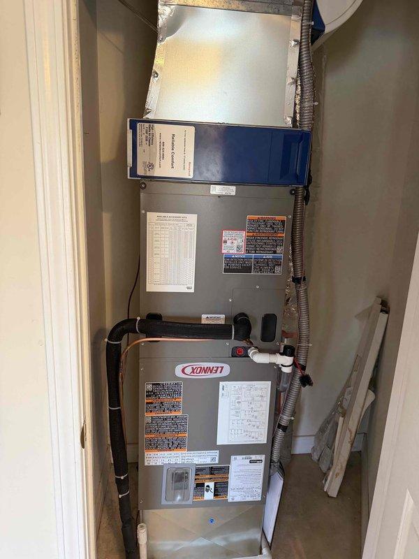 Successfully installed a complete Lennox heat pump system, including the digital thermostat with touchscreen display mounted on the interior wall. The installation included proper placement of the Lennox furnace unit in the utility closet with appropriate PVC drainage piping, blue filter housing, and connection to the existing ductwork, ensuring all components were properly secured and labeled for safety compliance.