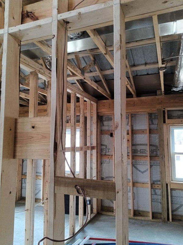 Completed installation of ERV intake and exhaust systems in new commercial construction during rough-in phase. Successfully ran thermostat wiring to indoor unit through exposed framing. All work performed according to specifications with proper integration into the existing wooden structural framework.