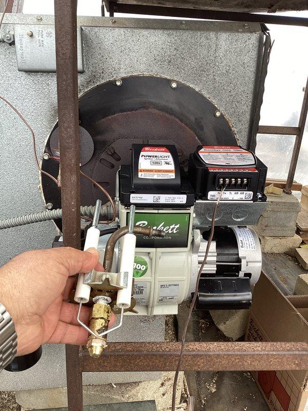 Diagnosed oil furnace leak occurring at air tube assembly during operation. Inspection revealed significant burn-through damage on the air tube component of the Beckett oil burner. Recommended replacement of air tube, nozzle, and orifice assembly to resolve oil leakage issue at the burner.