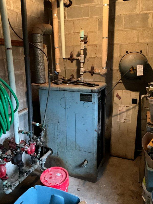 Conducted assessment for replacement of an aged propane boiler system in customer's basement. Existing installation shows significant wear with outdated electrical connections mounted on wooden backboard. Recommended replacement with new propane boiler system of comparable capacity, including proper electrical panel upgrades and PVC venting to meet current code requirements.