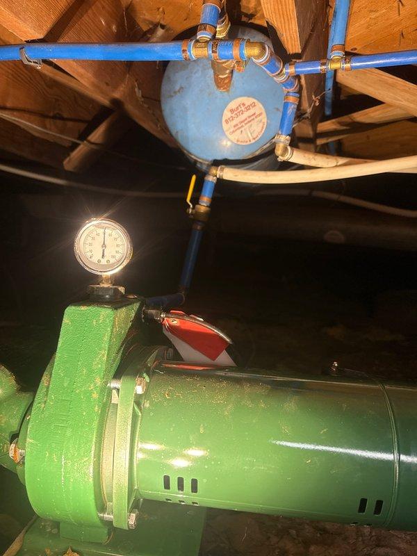 Conducted comprehensive plumbing inspection of basement water system, examining pump assembly with pressure gauge, expansion vessel, and PVC distribution piping. Inspected electrical connections at pump terminal assembly, verifying proper wiring of ground and power connections. All components were found to be functioning within normal parameters with no immediate service requirements.