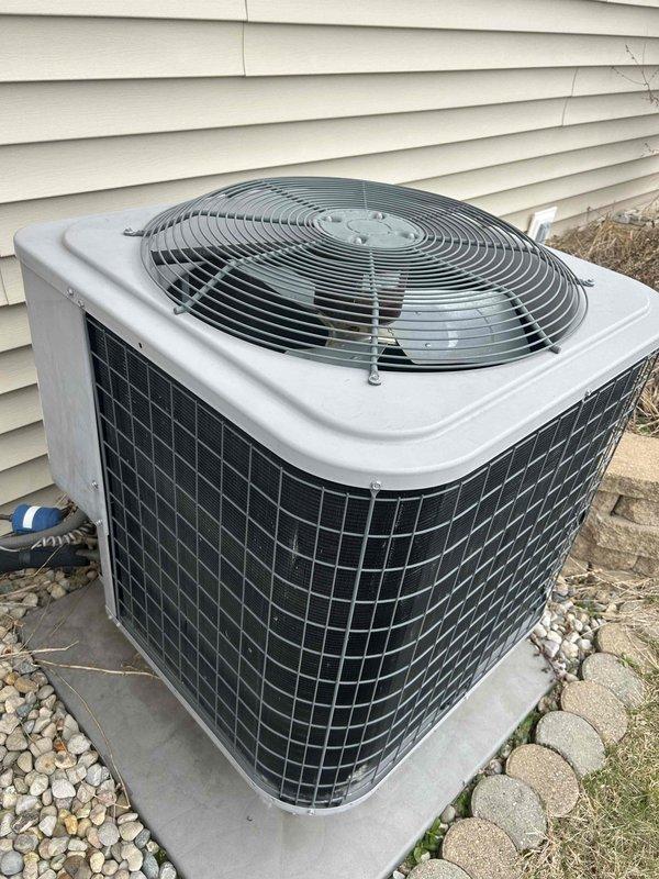 Conducted free second opinion service for non-cooling system that was blowing hot air. Diagnosed inoperative outdoor unit for upstairs with zero pressure reading and visible rust on top where unit had been running hot. Provided options for leak search or complete system replacement, noting that downstairs system was also underperforming. Documented condition with photos of both condenser units showing installation on concrete pad with proper clearance.