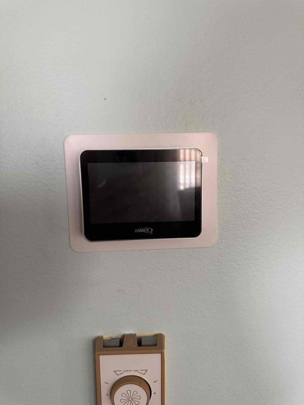 Successfully installed a complete Lennox AC system with air handler, utilizing the customer's existing baseboard heating system instead of a heater pack. Verified proper system installation using professional leveling tools and completed final setup of the digital thermostat control interface.