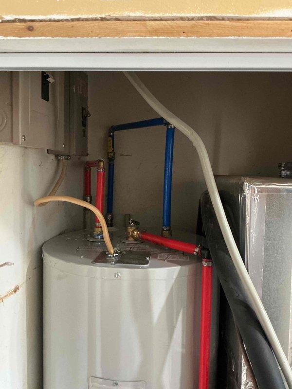Successfully installed a new tank water heater in utility area, including proper connection of hot and cold water lines with PEX piping. Replaced existing valves and secured unit on wooden platform, ensuring all connections were properly sealed and operational.