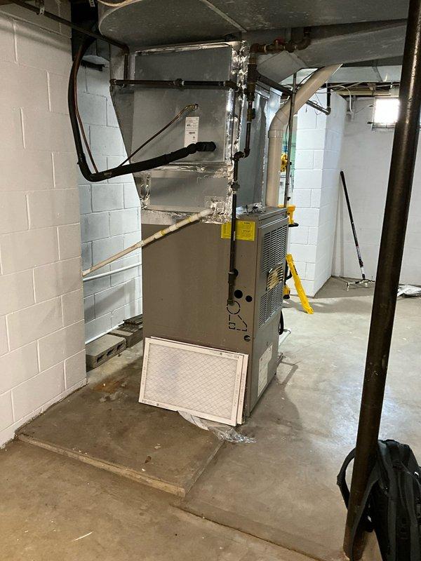 Inspected 1999 furnace exhibiting intermittent fault codes related to condensation issues in the collector box and inducer assembly. System evaluation revealed aging components in basement installation with visible water staining near unit base, confirming moisture problems. Recommended complete system replacement to address recurring faults and potential safety concerns, with options presented for compatible integration with existing 2023 Lennox AC unit.