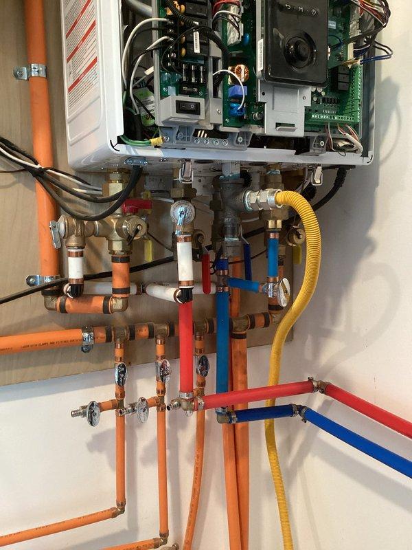 Diagnosed pressure and flow issues with Navien tankless water heater system. Inspected internal components including circuit boards and electronic systems. Evaluated PEX piping network and manifold distribution system, finding restriction in flow due to sediment buildup. Flushed system to remove accumulated debris and restore proper operation.