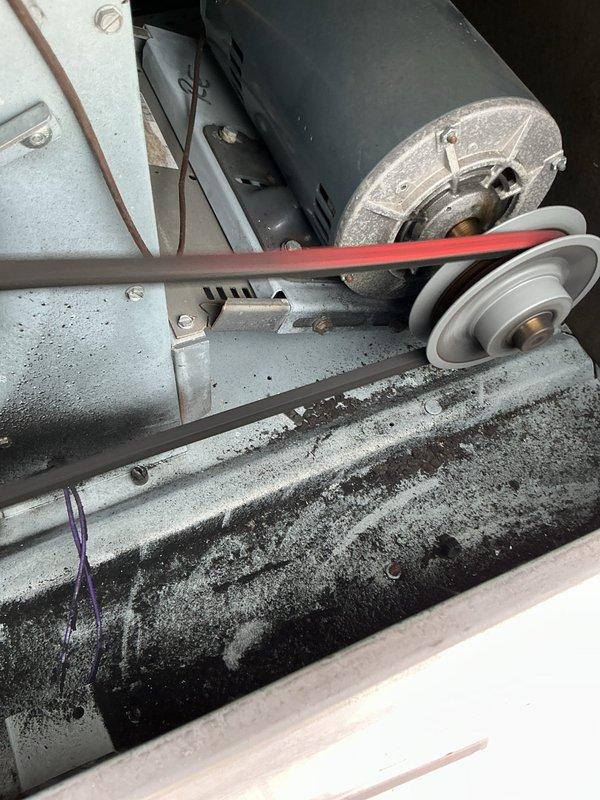 Performed routine maintenance on heating system, inspecting belt drive components and blower assembly. Noted dust accumulation on housing and pulley system, with belt showing normal wear. Documented filter requirements for future service: 12 (16x20x2), 4 (18x25x2), 12 (20x20x2), and 4 (16x16x2) filters needed; CCH Basic coverage extends until 05/21/2028.