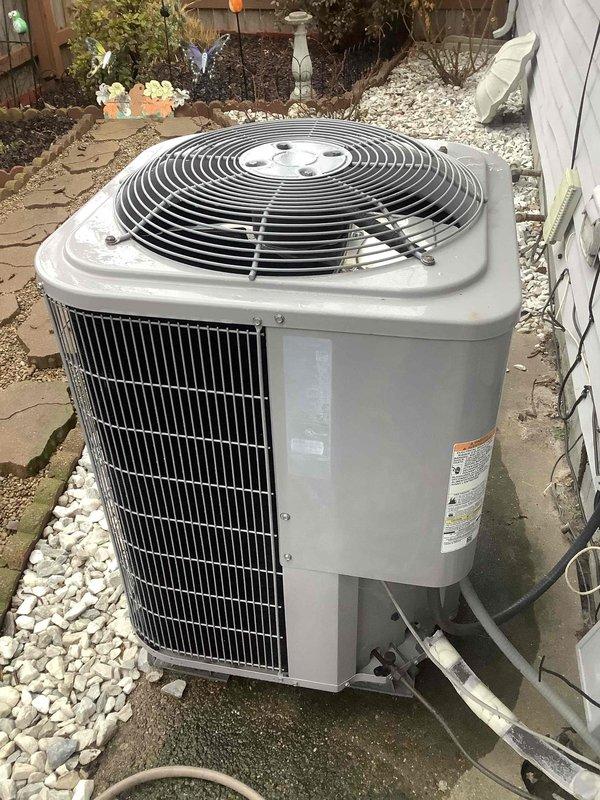 Performed Basic Plus maintenance on CCHP heating system. Inspected thermostat displaying "OFFLINE" status with heat mode active at 74°F. Evaluated outdoor unit condition, confirmed proper installation on gravel bed with intact connections to building.