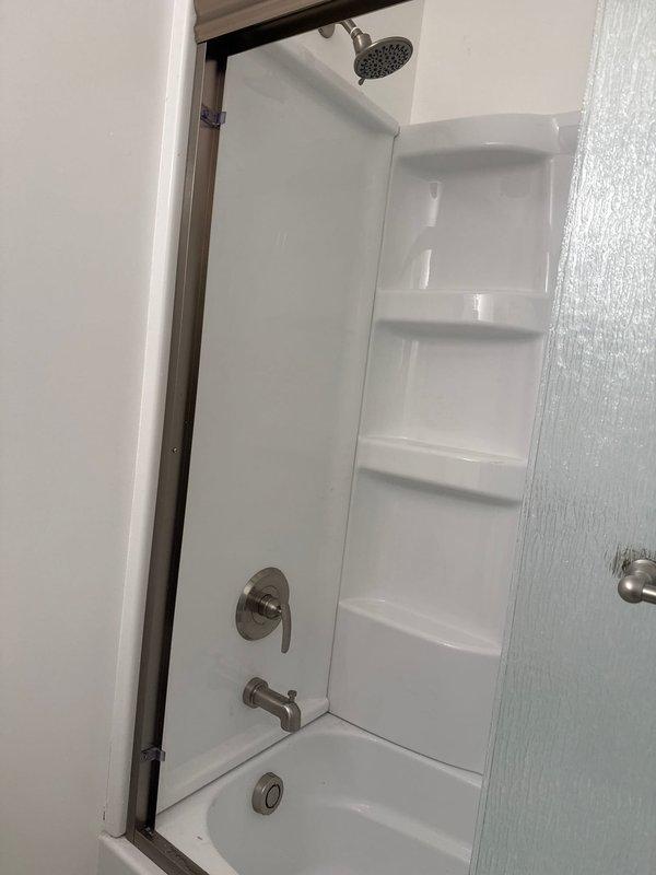 Secured two loose shower heads in wall mounts and restored hot water flow to guest bathroom shower by clearing obstructions in the hot water supply line and adjusting the mixing valve.