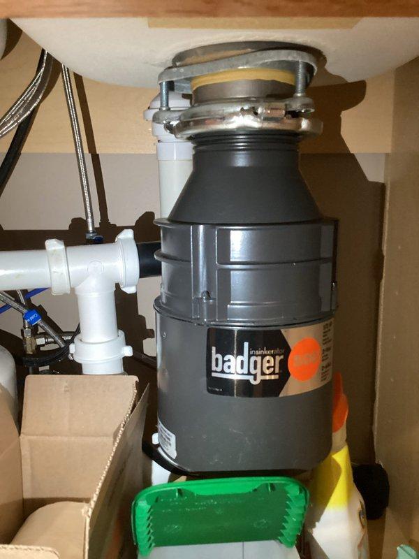 Completed annual plumbing inspection service with focus on kitchen and bathroom fixtures. Inspected under-sink garbage disposal (Badger brand) for proper installation and function, verifying secure connections to PVC drainage pipes. Examined bathroom shower control valve and associated plumbing components including braided metal hose and water supply lines, confirming proper installation and absence of leaks. Photographic documentation was taken of all inspected areas.