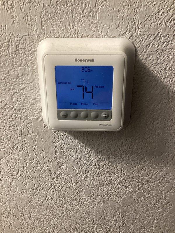 Performed monthly basic heating maintenance service on the system. Inspected outdoor condensing unit and verified proper installation on concrete pad with adequate clearance. Checked Honeywell ProSeries thermostat operation, confirming proper heat mode function with temperature reading at 74°F and fan in auto setting.