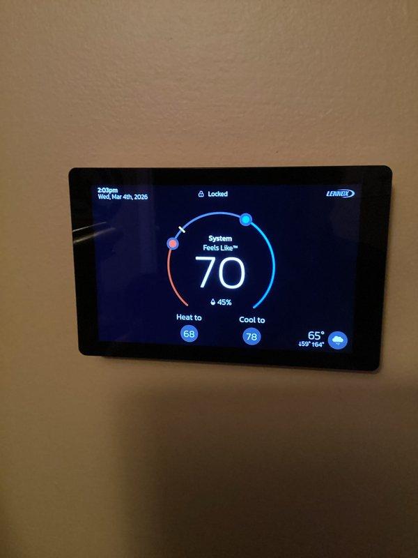 Performed annual maintenance service on Lennox CCHP heating system (renewal due 8/10/27). Inspected and verified proper operation of thermostat interface showing normal temperature readings and system response. Examined control board connections and wiring at exterior disconnect panel, confirming all components were properly secured and functioning. Replaced air filter as part of scheduled maintenance protocol.