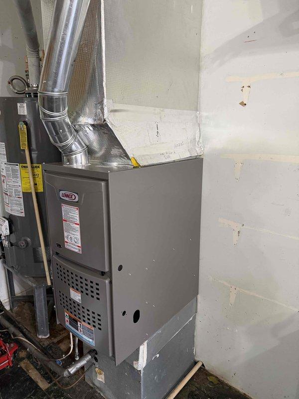 Successfully installed a Lennox 80% Gas Furnace in utility room with proper ductwork connections and transition box extending to ceiling area. Verified system operation with temperature readings showing 124.1°F at supply plenum, confirming proper heat exchange. Installation completed with all necessary gas line connections and safety checks performed.