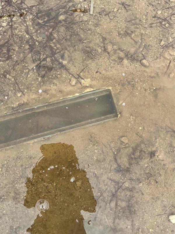 Responded to service call for clogged exterior drainage channel. Successfully cleared blockage of debris and soil that had accumulated in the rectangular metal drain, which was causing water pooling and overflow onto the surrounding ground surface. Performed camera inspection to verify proper water flow was restored and no underlying structural issues were present.