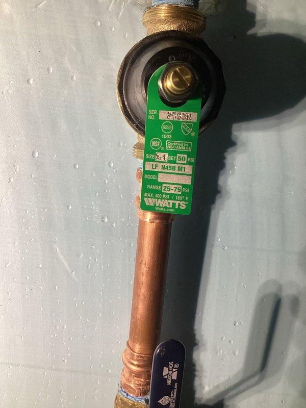 Successfully installed a new 3/4" Watts pressure reducing valve (25-75 PSI range) and thermal expansion tank on the customer's copper water supply line. PRV was properly calibrated to 50 PSI to protect plumbing fixtures and prevent excessive pressure in the system. Verified proper operation of both components and confirmed no leaks at connection points.