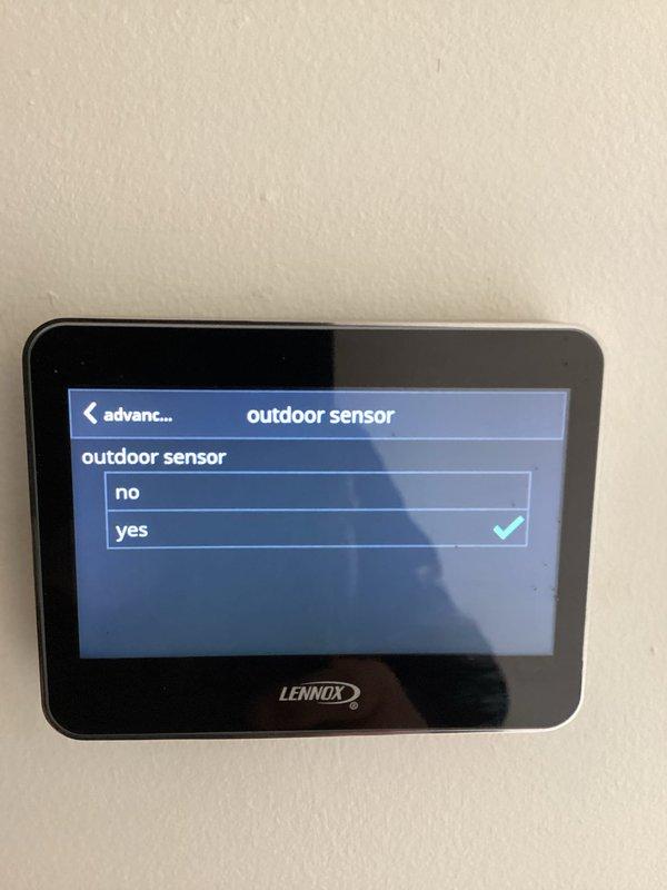 Performed diagnostic assessment on Lennox heat pump system reporting thermostat ambient lockout issues. Verified temperature discrepancy between thermostat reading (76°F) and actual ambient temperature (71.2°F per calibrated PDT22 probe). Corrected system configuration by enabling outdoor sensor setting in thermostat programming menu, resolving continuous operation problem and restoring normal cycling function.