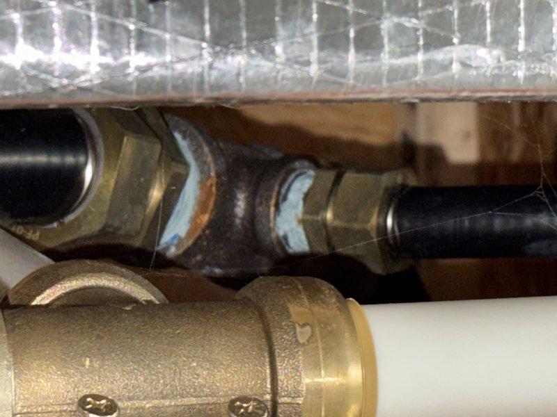 Performed comprehensive inspection of gas system including stove and fireplace insert connections. Located and documented brass fittings and connection points in confined space with visible solder marks. Customer requested removal of gas log fireplace insert with subsequent line capping; provided estimate for complete service including leak detection and proper gas line termination.