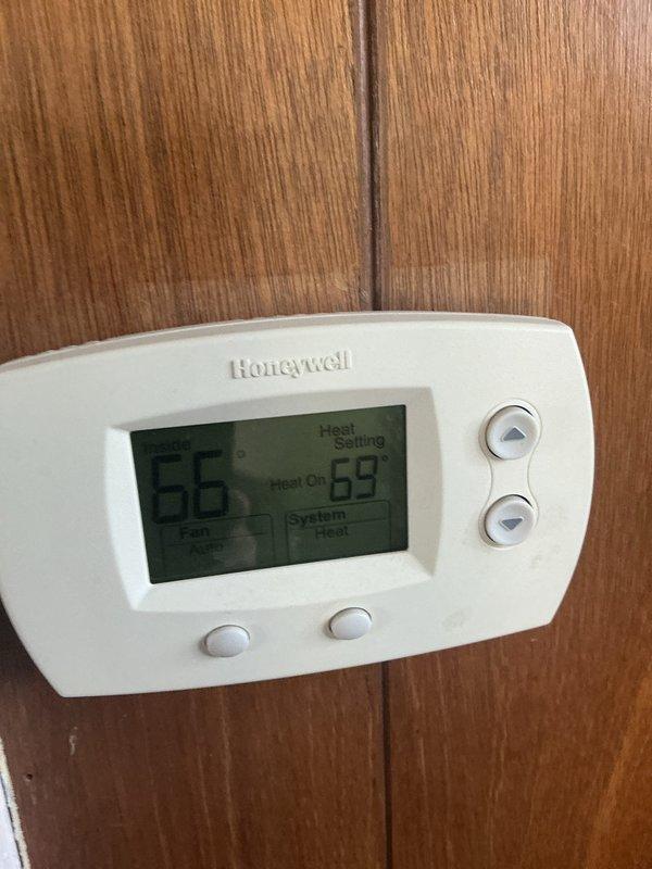 Performed heat maintenance service on Honeywell thermostat system (CCH, Renew-8/8/26). Observed thermostat functioning properly with heat setting at 69° and current temperature reading at 56°. Noted significant rust and corrosion on outdoor unit cooling fins, with deterioration along bottom edge requiring attention in future service. Filter size was undetermined during this visit.