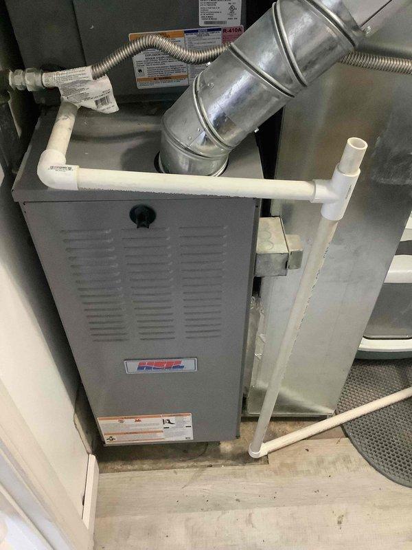Performed diagnostic assessment on residential HVAC system following reported ongoing issues after major system rework. Inspected both furnace unit (with HEE logo) and outdoor AC condenser unit, utilizing pressure testing equipment to evaluate system performance and determine warranty eligibility.