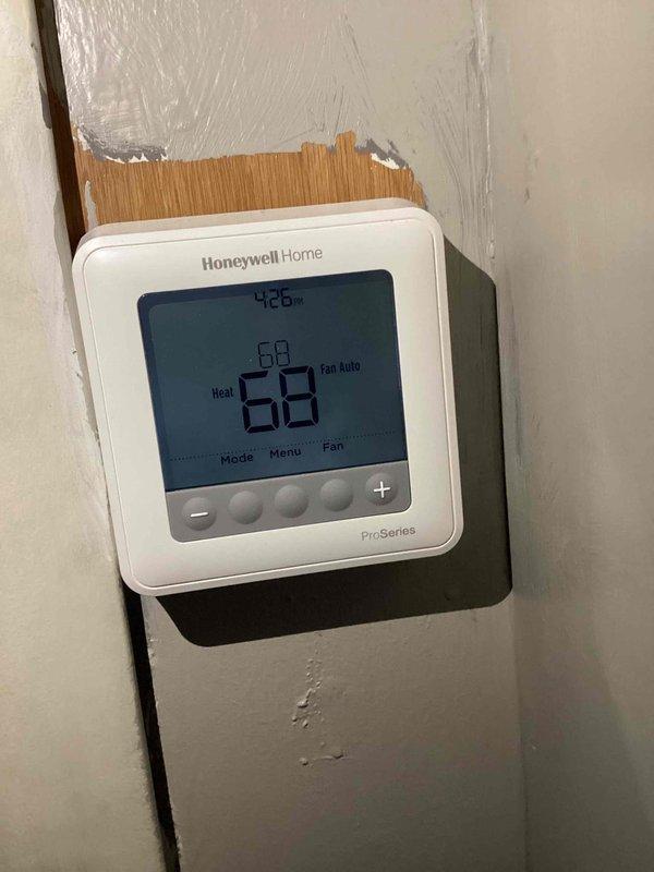 Performed standard CCH Basic Monthly maintenance service on heating system. Verified Honeywell Home Pro-Series thermostat functionality, confirming proper operation in "Heat" mode with temperature set at 68°. Noted wall damage around thermostat mounting area but equipment remains securely installed and fully operational.