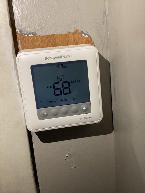 Performed standard CCH Basic Monthly maintenance service on heating system. Verified Honeywell Home Pro-Series thermostat functionality, confirming proper operation in "Heat" mode with temperature set at 68°. Noted wall damage around thermostat mounting area but equipment remains securely installed and fully operational.