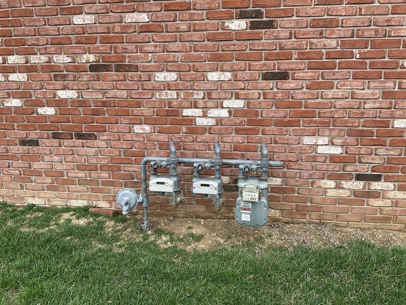 Conducted site assessment of residential property to evaluate conversion from existing heat pump system to gas heating system. Inspected exterior gas meter installation and connection points to determine capacity for supporting new gas furnace. Confirmed appropriate exterior space for potential equipment placement near windows with adequate clearance from landscaping elements.