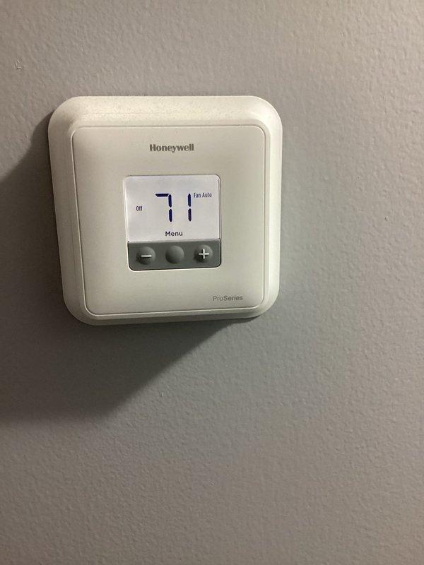 Performed after-hours tune-up on HVAC system to address customer's high utility bill concerns. Inspected Honeywell ProSeries thermostat wiring connections and verified proper terminal connections (R,G,Y,W). Confirmed system operation with thermostat showing 71°F temperature reading and proper fan auto function.