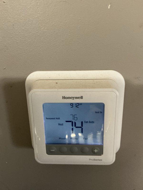 Performed scheduled monthly maintenance on CCHP heating system. Inspected thermostat (Honeywell ProSeries) confirming proper operation in heat mode at 74°F with 76°F setpoint. Examined evaporator coil assembly which shows normal oxidation on copper components consistent with system age; all connections remain secure with no visible leaks detected.