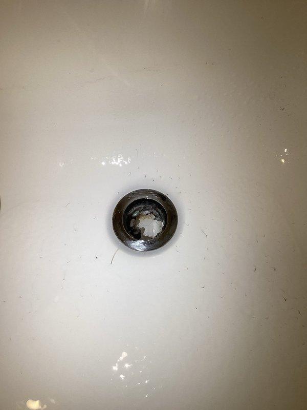 Diagnosed and repaired multiple plumbing issues including continuously running toilets and slow dripping sinks. Inspected shower/tub fixture showing significant mineral buildup on escutcheon plate and handle, as well as drain with visible tarnishing and mineral deposits. Discussed potential kitchen sink replacement options with customer.