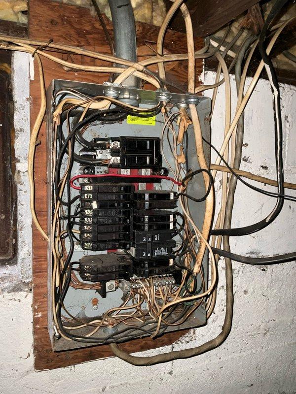 Conducted assessment of 27-year-old furnace in rental property requiring major repairs; recommended full replacement as the most cost-effective solution. Documented existing electrical panel with outdated fabric-covered wiring and inspected current OilStar furnace installation with metal ductwork in unfinished basement. Replacement recommended due to age of unit, deteriorating condition, and long-term economic benefits versus repair costs.