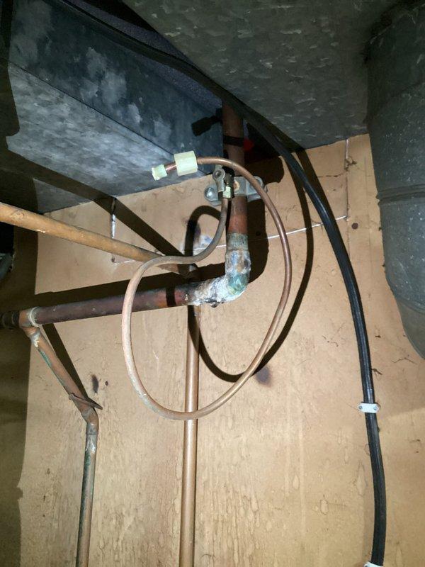 Responded to service call for non-functioning 40-gallon tank water heater that would not relight. Inspection revealed significant corrosion at copper pipe joints and connections, particularly where the pipe bends, with advanced green patina development indicating prolonged moisture exposure. Multiple pipe sections showed evidence of previous repairs with tape/insulation, and replacement was recommended due to deteriorated condition.