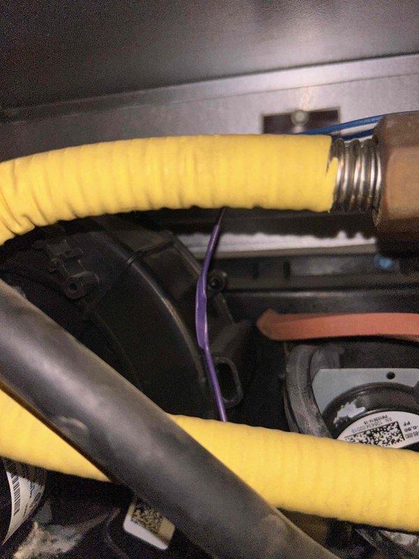 Responded to service call for a furnace not providing adequate heat. Upon inspection, examined the inducer motor assembly and associated components including the yellow insulated flexible hose and black rubber tubing connections. Verified system operation and identified potential issues with the inducer motor as initially suspected.