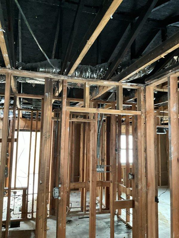 Conducted site assessment for complete HVAC system and line replacement following fire damage. Inspection revealed exposed framing, damaged concrete flooring with cutouts, and compromised electrical components requiring full system replacement. Documented existing ductwork configuration and structural conditions to prepare comprehensive replacement estimate for restoration of the fire-damaged HVAC infrastructure.