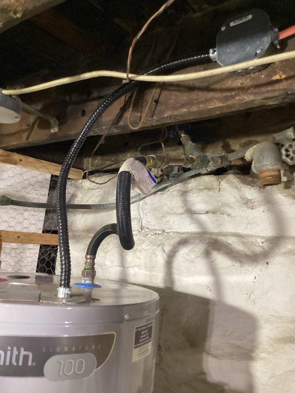 Conducted monthly plumbing inspection of the property, examining the water softener system and salt pellet levels in the brine tank. Inspected the A.O. Smith 100-gallon water heater, checking all connections, flexible conduits, and copper pipe fittings for proper function and potential leaks throughout the basement utility area.