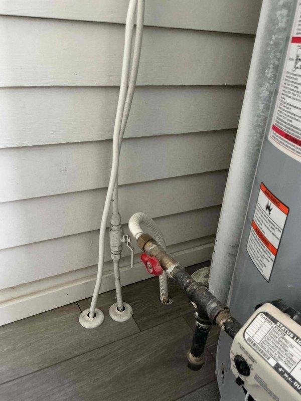 Investigated water heater making popping sounds during hot water usage. Inspected exterior plumbing connections including shut-off valve assembly and insulated pipe sections. Determined the cause to be mineral sediment buildup in tank, which creates the popping noise when heated water rises through deposits.