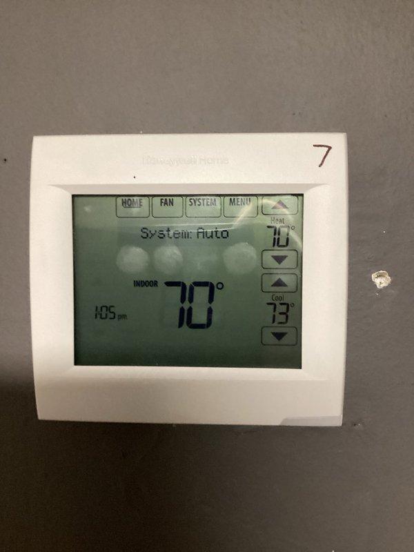 Responded to service call for two units not cooling properly. Inspected thermostats (confirmed one set to 73°F in cooling mode) and examined rooftop condensing units. Observed significant rust on condenser fan guard and housing, indicating exposure damage. System was operational at time of inspection with proper temperature differential.