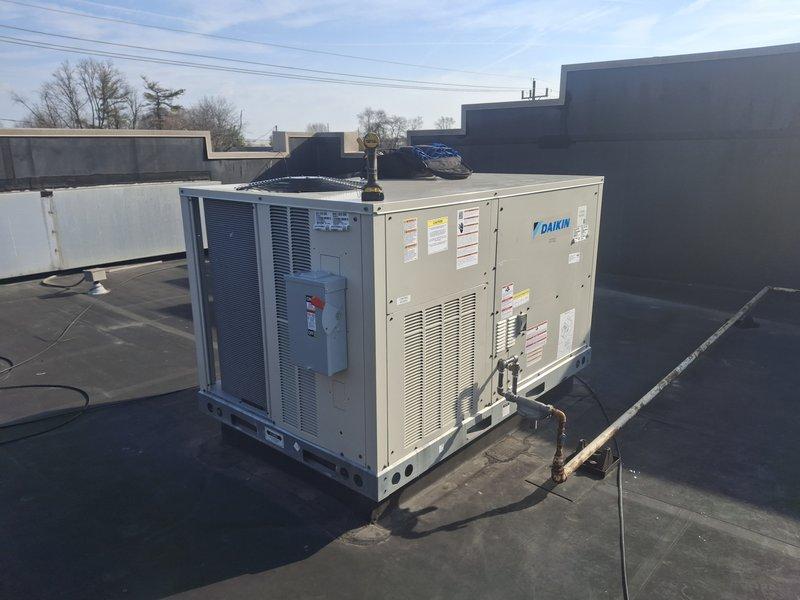 Performed warranty inspection on Daikin rooftop commercial HVAC system. Examined and verified proper operation of White-Rodgers digital thermostat (setpoint 75°F). Documentation photos taken of both thermostat installation and rooftop unit for warranty verification purposes.