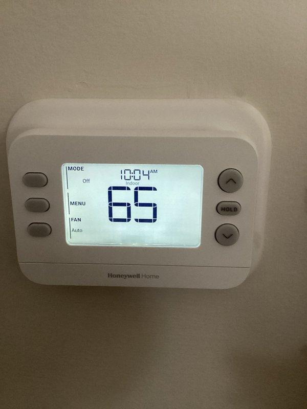 # Service Summary

Responded to service call for non-operational outdoor condenser fan on residential Lennox air conditioning system. Upon arrival, conducted visual inspection of exterior condenser unit and verified customer complaint of fan not spinning. Examined Lennox condenser unit positioned on concrete pad with proper clearance and landscaping. Assessed refrigerant line connections, electrical components, and overall unit condition.

Checked indoor Honeywell Home digital thermostat showing system in OFF mode with fan set to AUTO position. Verified thermostat programming and system settings at control interface. Diagnosed fan motor failure preventing proper condenser operation and heat rejection from refrigeration cycle.

Replaced defective condenser fan motor with OEM-compatible component. Tested capacitor and contactor functionality to ensure proper electrical supply to new motor. Verified proper fan blade rotation direction and secure mounting. Energized system and confirmed co