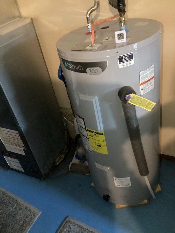 # Service Summary

Responded to no cooling call on system less than 10 years old. Upon arrival, customer reported unit had lost cooling capability the previous day and heating function had also failed, requiring use of emergency heat mode. Performed diagnostic evaluation of HVAC system and water heater equipment located in utility area. Documented equipment conditions including AO Smith water heater model 100 and adjacent HVAC unit. Inspected outdoor unit placement, electrical connections, and surrounding area for potential issues. Assessed system components, control settings, and operational status to determine root cause of heating and cooling failures.