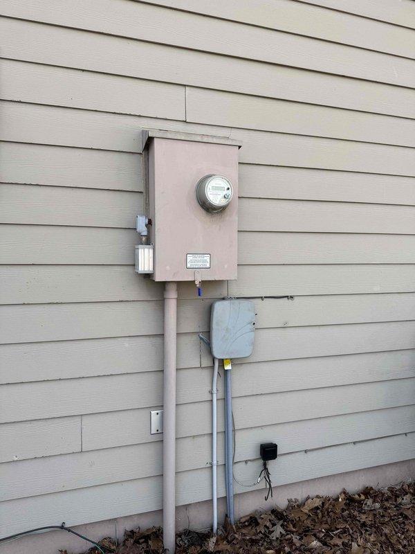 Completed residential standby generator installation with full electrical integration. Installed exterior generator transfer switch and weatherproof disconnect box on building exterior with proper conduit routing from main electrical panel. Mounted automatic transfer switch panel and associated control components in garage, establishing connection between utility power, generator output, and critical circuit distribution to enable seamless automatic power transfer during outages.