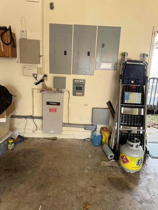Completed residential standby generator installation with full electrical integration. Installed exterior generator transfer switch and weatherproof disconnect box on building exterior with proper conduit routing from main electrical panel. Mounted automatic transfer switch panel and associated control components in garage, establishing connection between utility power, generator output, and critical circuit distribution to enable seamless automatic power transfer during outages.