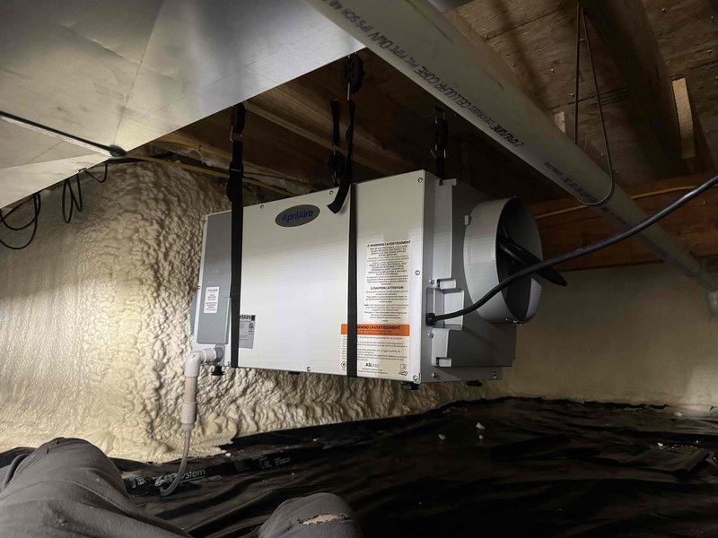 Completed installation of Aprilaire E100 indoor air quality system integrated with existing Weatherking air handler unit in attic space. Mounted and leveled IAQ equipment, verified proper positioning using precision leveling instruments, and connected unit to ductwork system. Ensured all electrical connections were properly secured and system was operational within manufacturer specifications.