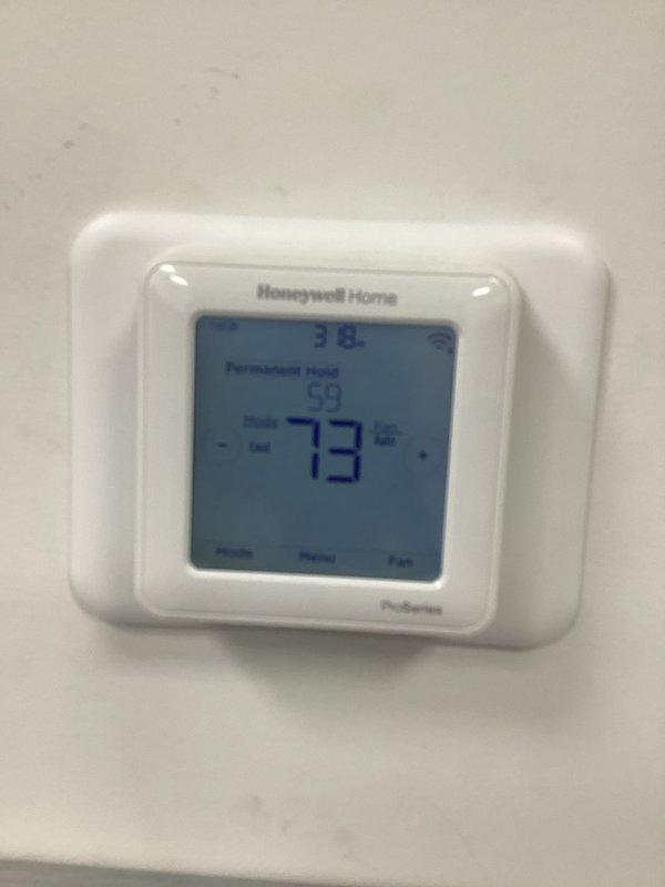 Responded to diagnostic service call for conventional HVAC system with ceiling-mounted equipment. Upon arrival, evaluated Honeywell Home ProSeries thermostat displaying 73°F with permanent hold setting active. Documented thermostat operation and display readings for diagnostic purposes to determine system performance issues.