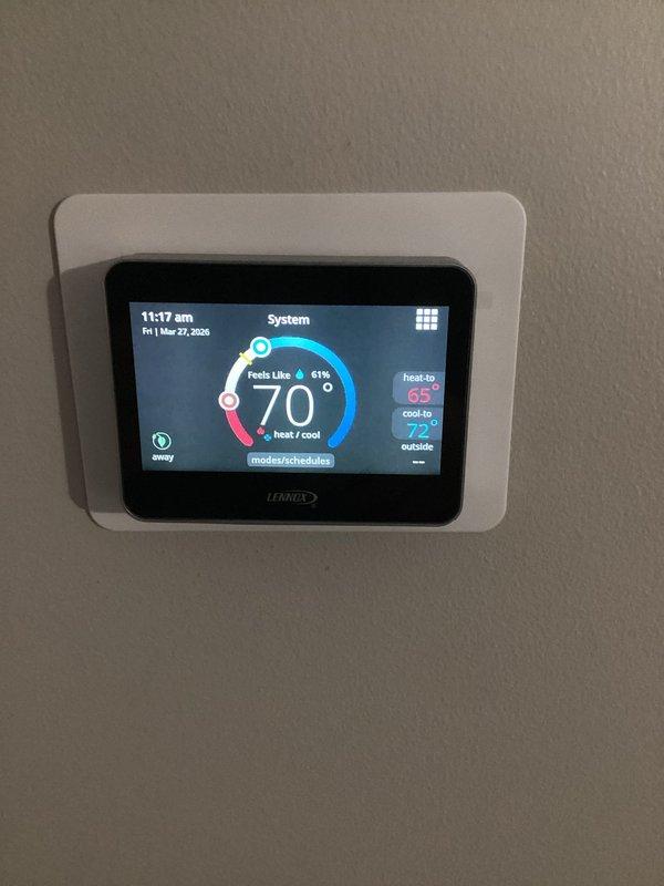 Returned to property to complete thermostat replacement, successfully installing new Lennox M30 smart thermostat. Unit was mounted, programmed with heating and cooling setpoints, and verified operational with touchscreen display showing proper temperature readings and system status.