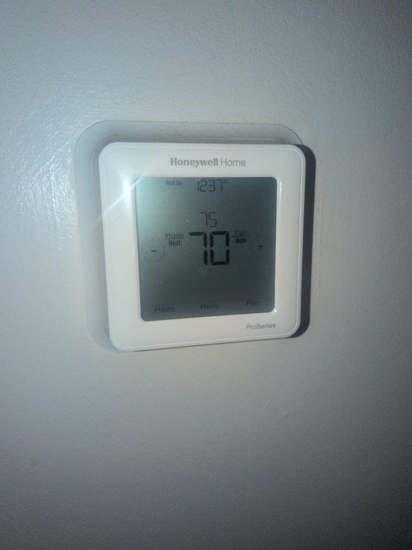 Completed basic monthly heating maintenance on HVAC system. Verified thermostat operation showing proper heat mode functionality at 70°F setpoint. Inspected air handling unit interior, including flexible connector assembly and internal components, documenting current system condition with no immediate service needs identified at this time.